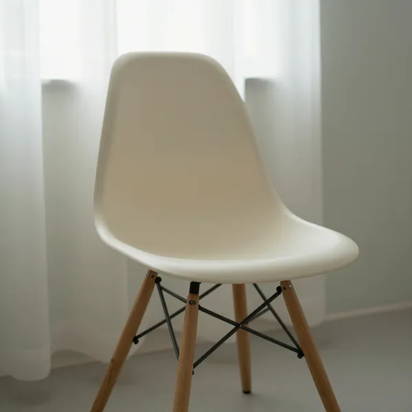 Illustrative: mid-century molded fiberglass shell chair on a wood dowel base, first-run production